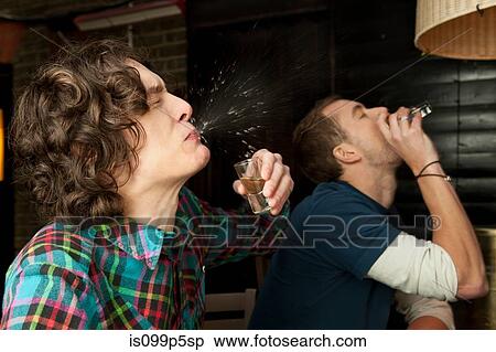 Stock Photography - Two men drinking shots. Fotosearch
