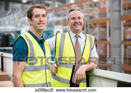 Two men in warehouse, portrait View Large Photo Image Stock Image - Two men in warehouse, portrait. Fotosearch