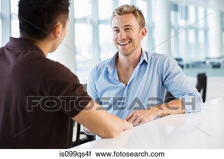 Two young businessmen talking View Large Photo Image Stock Image - Two young businessmen talking. Fotosearch