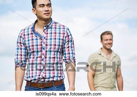 Two young men outdoors, focus on man in foreground View Large Photo Image Stock Image - Two young men outdoors, focus on man in foreground. Fotosearch
