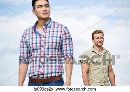 Two young men outdoors, focus on man in background View Large Photo Image Stock Photo - Two young men outdoors, focus on man in background. Fotosearch