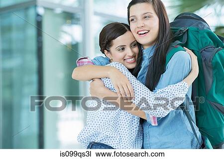 Woman embracing friend with backpack View Large Photo Image Stock Image - Woman embracing friend with backpack. Fotosearch