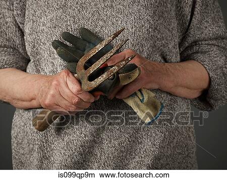 Woman holding gardening glove and trowel View Large Photo Image Picture - Woman holding gardening glove and trowel. Fotosearch