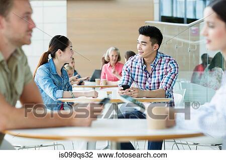 Stock Image - Young couple in canteen area. Fotosearch