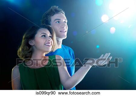 Young couple looking up at light View Large Photo Image Stock Image - Young couple looking up at light. Fotosearch