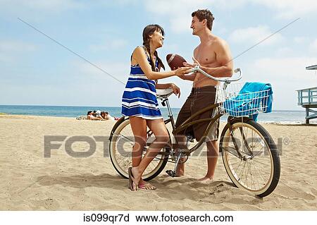 Young couple on beach with bicycle View Large Photo Image Stock Image - Young couple on beach with bicycle. Fotosearch