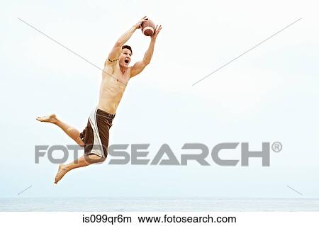 Young man catching rugby ball View Large Photo Image Picture - Young man catching rugby ball. Fotosearch