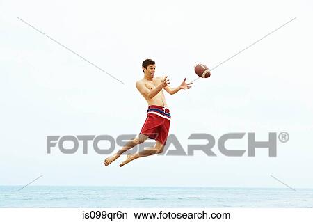 Young man catching rugby ball View Large Photo Image Picture - Young man catching rugby ball. Fotosearch