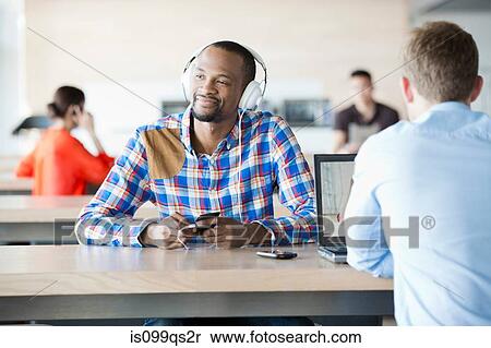 Young man in break room listening to music View Large Photo Image Stock Photography - Young man in break room listening to music. Fotosearch