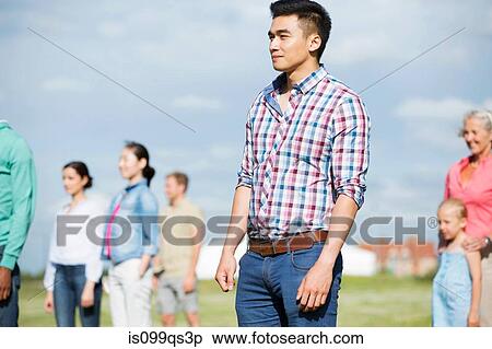 Young man standing in front of group of people outdoors View Large Photo Image Stock Photography - Young man standing in front of group of people outdoors. Fotosearch