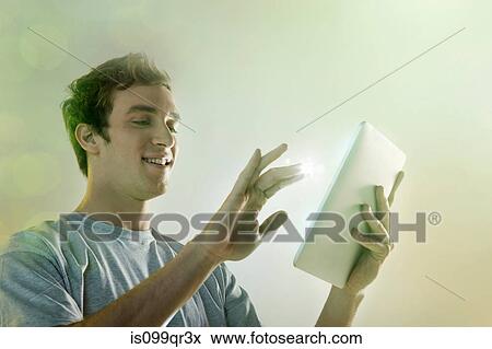 Young man using digital tablet with lights View Large Photo Image Stock Photo - Young man using digital tablet with lights. Fotosearch