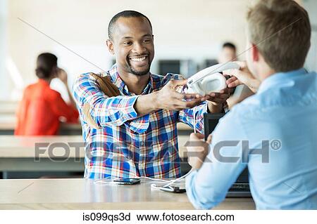 Young men sharing headphones View Large Photo Image Stock Image - Young men sharing headphones. Fotosearch
