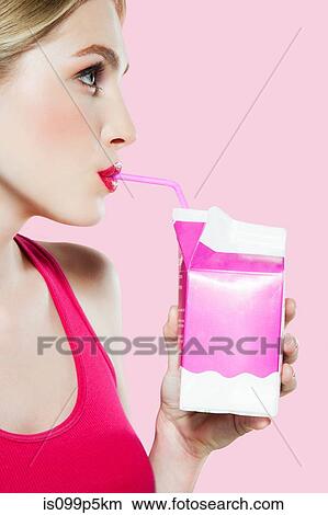Young woman drinking carton of milk through straw View Large Photo Image Picture - Young woman drinking carton of milk through straw. Fotosearch