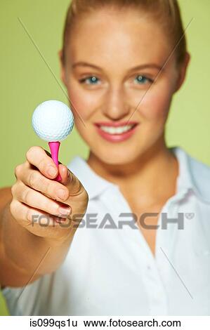 Young woman holding golf ball and tee View Large Photo Image Stock Photograph - Young woman holding golf ball and tee. Fotosearch