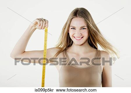 Young woman holding tape measure View Large Photo Image Stock Photography - Young woman holding tape measure. Fotosearch