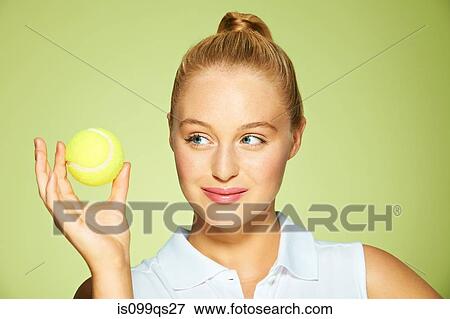 Stock Photo - Young woman holding tennis ball. Fotosearch