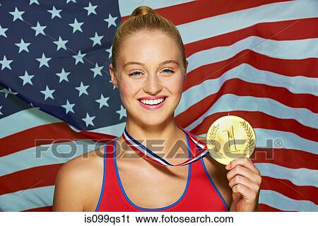 Stock Photograph - Young woman in front of USA flag with gold medal. Fotosearch