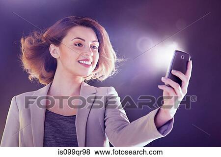 Young woman looking at cellphone with lights View Large Photo Image Stock Photo - Young woman looking at cellphone with lights. Fotosearch