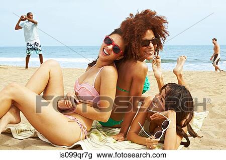 Young women sitting on beach View Large Photo Image Stock Image - Young women sitting on beach. Fotosearch