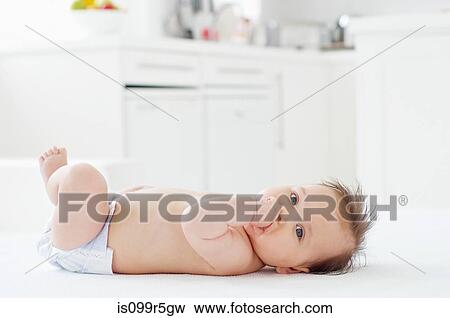 Stock Photo - Baby girl lying on back. Fotosearch