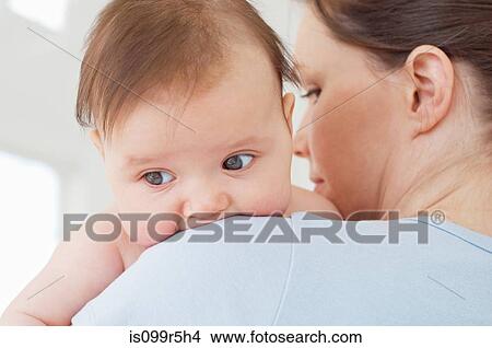 Baby girl on mother's shoulder View Large Photo Image Picture - Baby girl on mother's shoulder. Fotosearch