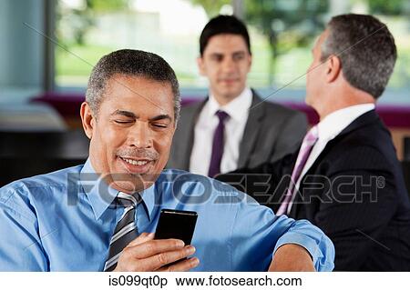 Stock Photography - Businessman texting on smartphone. Fotosearch