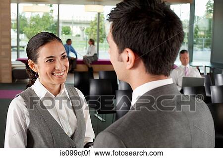 Stock Image - Businesspeople having conversation, high angle. Fotosearch