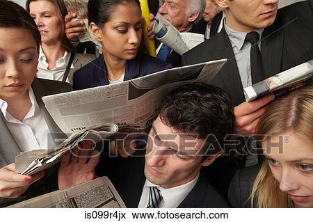 Businesspeople reading newspapers on crowded train View Large Photo Image Stock Photo - Businesspeople reading newspapers on crowded train. Fotosearch