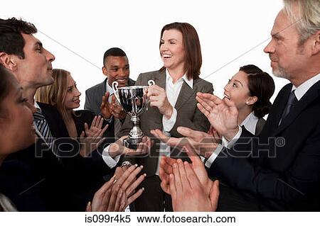 Stock Photography - Businesswoman receiving trophy, colleagues clapping. Fotosearch
