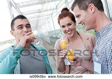 Stock Photo - Colleagues drinking orange juice. Fotosearch