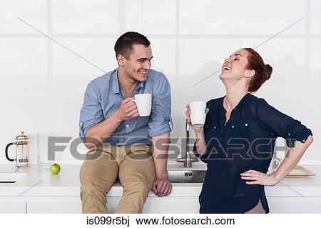 Stock Image - Colleagues laughing in kitchen. Fotosearch