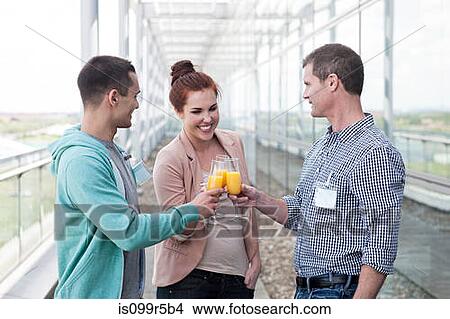 Colleagues toasting with orange juice View Large Photo Image Picture - Colleagues toasting with orange juice. Fotosearch