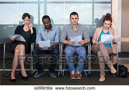 Four people sitting on chairs with documents View Large Photo Image Stock Image - Four people sitting on chairs with documents. Fotosearch
