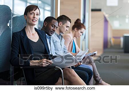 Four people sitting on chairs with documents View Large Photo Image Stock Photo - Four people sitting on chairs with documents. Fotosearch