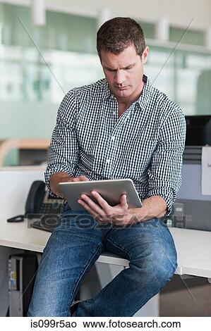 Man concentrating on digital tablet View Large Photo Image Picture - Man concentrating on digital tablet. Fotosearch