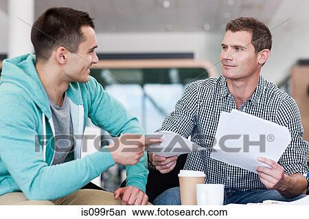Man giving colleague document View Large Photo Image Picture - Man giving colleague document. Fotosearch