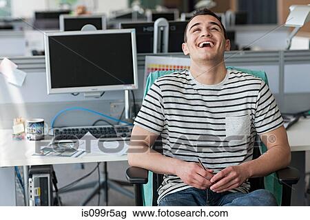 Man laughing in office View Large Photo Image Stock Image - Man laughing in office. Fotosearch