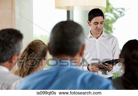 Stock Photograph - Man using digital tablet in business meeting. Fotosearch