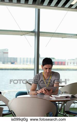 Stock Image - Man using digital tablet in cafe. Fotosearch