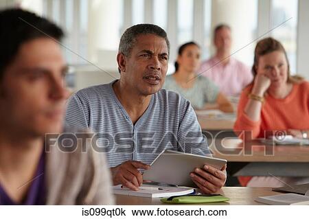 Stock Image - Man using digital tablet in class. Fotosearch