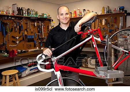 Man with bicycle in repair shop View Large Photo Image Stock Image - Man with bicycle in repair shop. Fotosearch