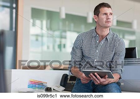 Man with digital tablet looking away View Large Photo Image Stock Image - Man with digital tablet looking away. Fotosearch