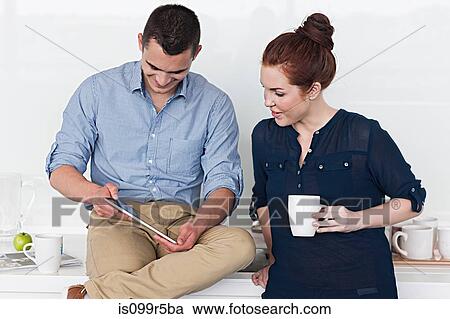 Man with digital tablet, woman holding coffee View Large Photo Image Stock Image - Man with digital tablet, woman holding coffee. Fotosearch