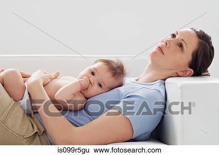 Mother and baby girl on sofa View Large Photo Image Stock Photograph - Mother and baby girl on sofa. Fotosearch