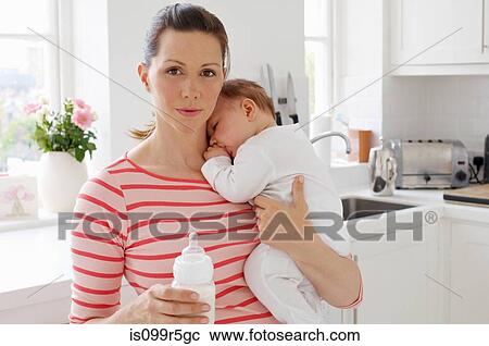 Mother holding baby girl and bottle View Large Photo Image Stock Image - Mother holding baby girl and bottle. Fotosearch