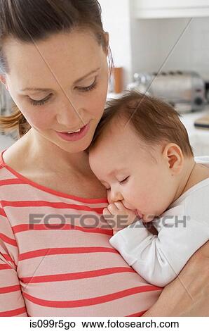 Picture - Mother holding sleeping baby girl. Fotosearch
