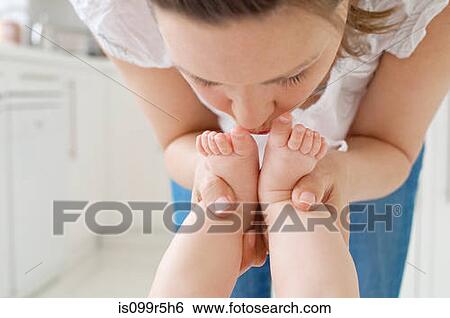 Mother kissing baby's feet View Large Photo Image Stock Photograph - Mother kissing baby's feet. Fotosearch