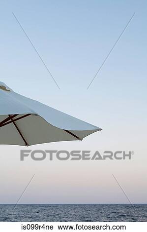 Parasol by the ocean at sunset View Large Photo Image Stock Image - Parasol by the ocean at sunset. Fotosearch