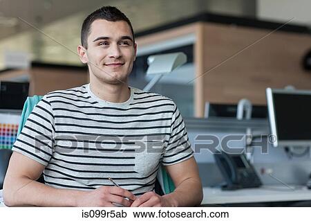 Stock Image - Portrait of man smiling in office. Fotosearch