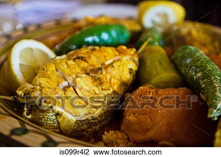 Stock Image - Tunisian restaurant dish of grouper with vegetables, Djerba. Fotosearch